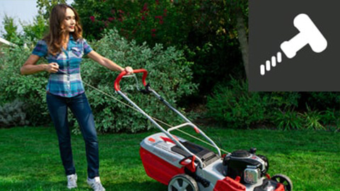 a woman pushing a lawn mower