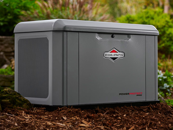 Standby generator in landscaping near a house.