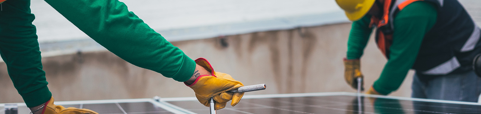 Two workers installing a solar panel.