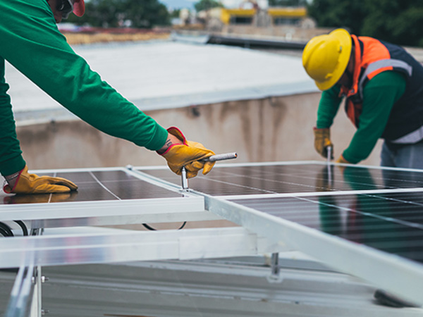 Two workers installing a solar panel.