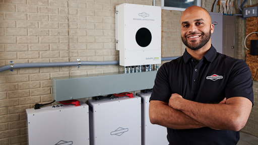 Installer Standing Proudly in front of SimpliPHI Batteries Wall Mount
